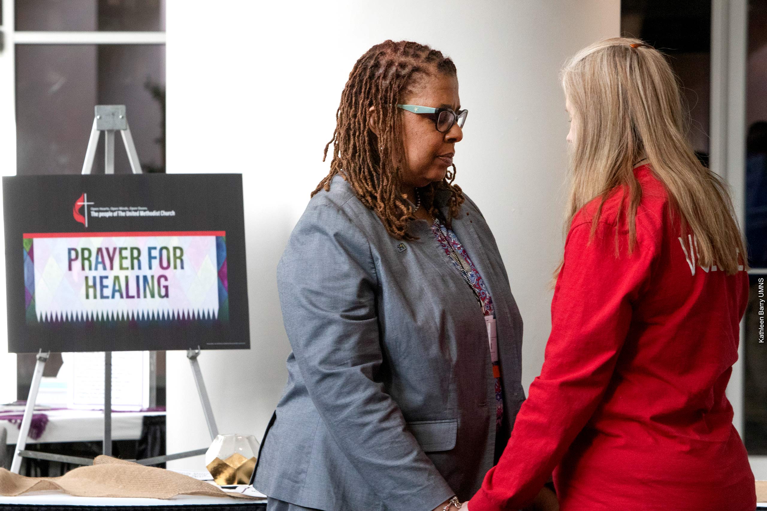 Yvette Richards and Jennifer Long pray together at the 2019 General Conference in St. Louis.