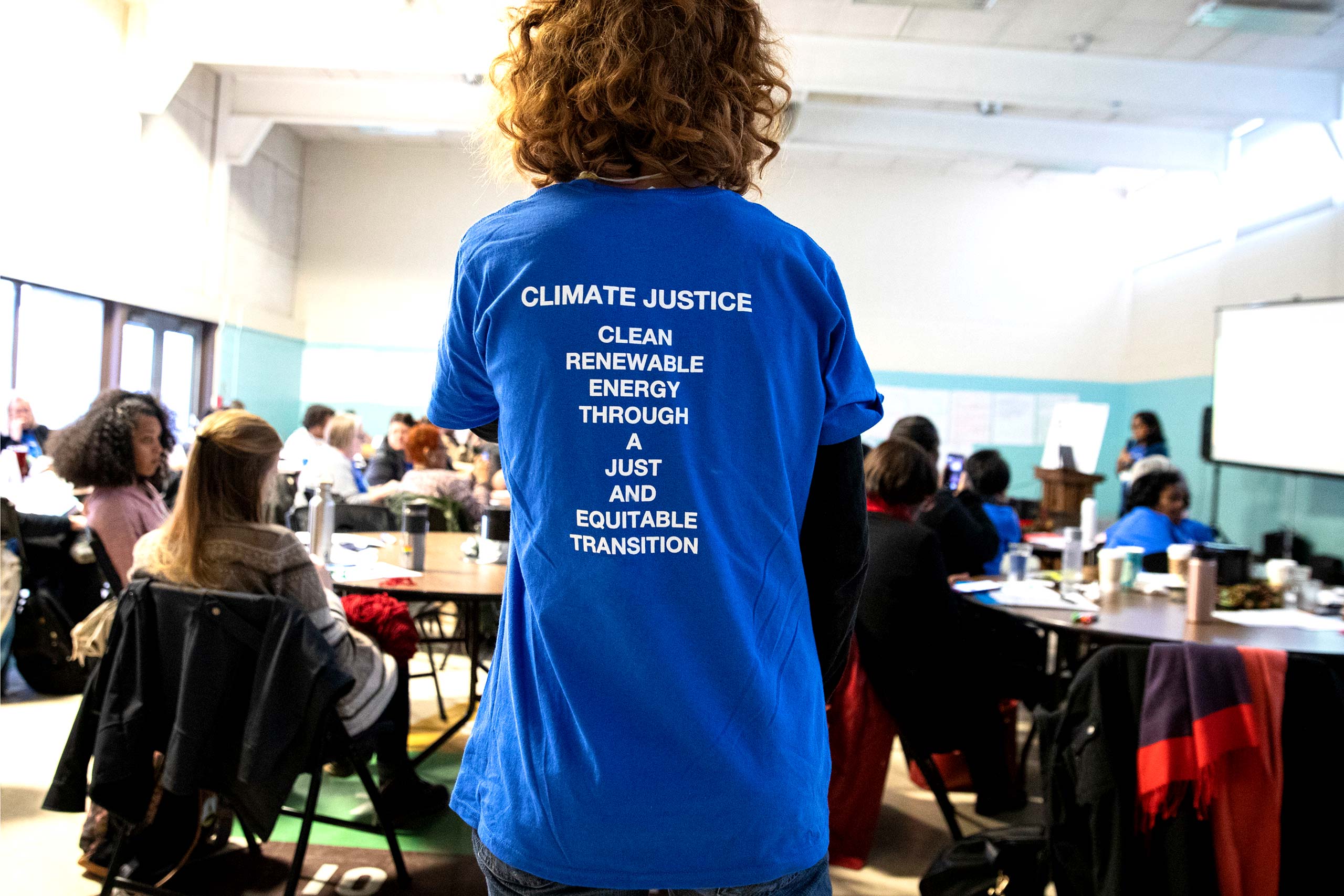 back of woman wearing a climate justice t-shirt
