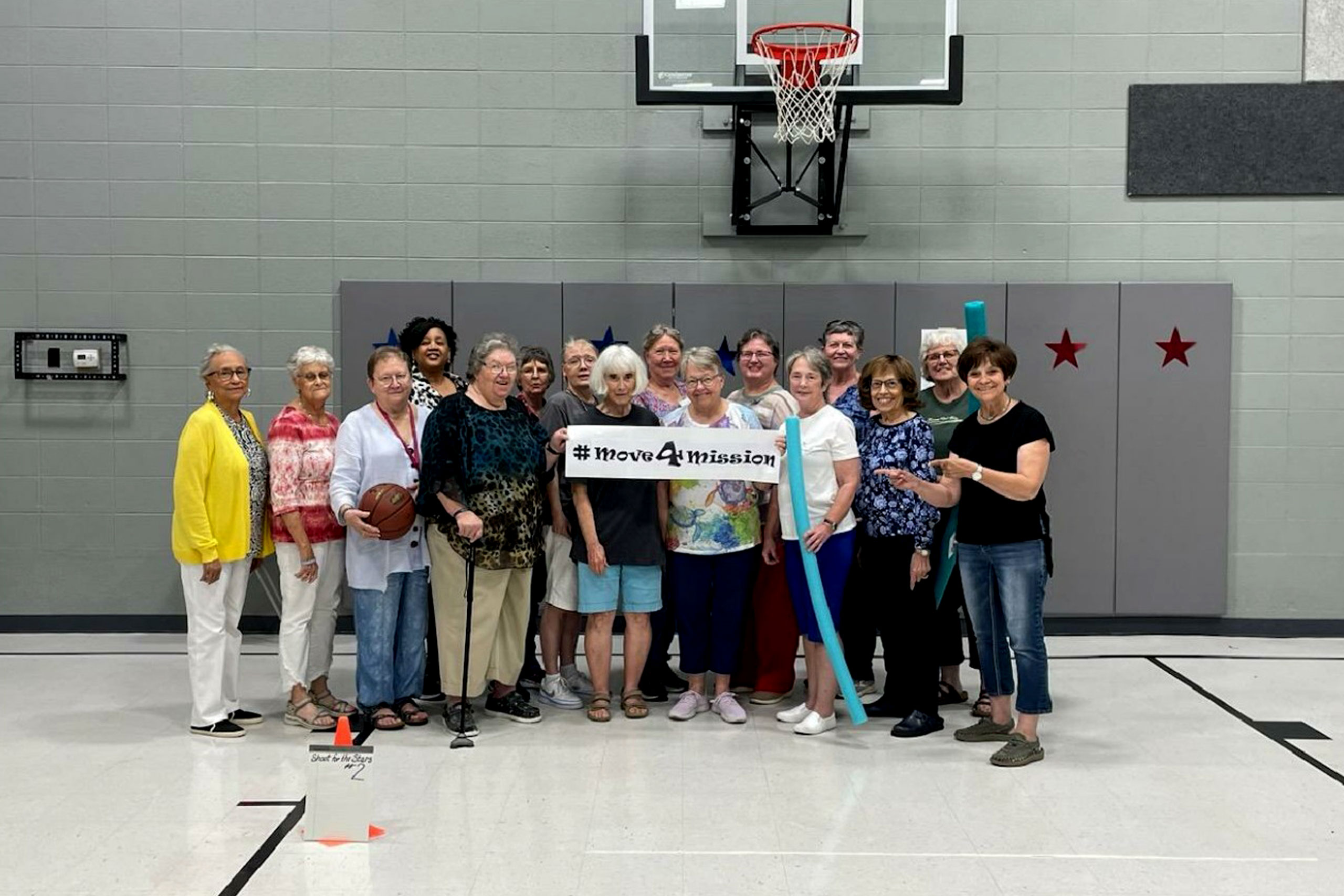 Group of women pose with a Move 4 Mission sign