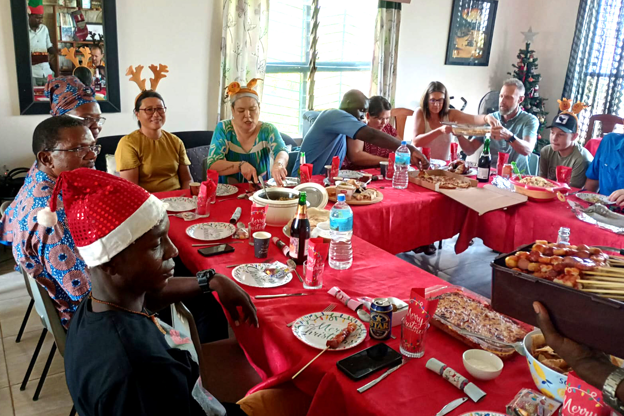 a group of people at a table eating Christmas dinner